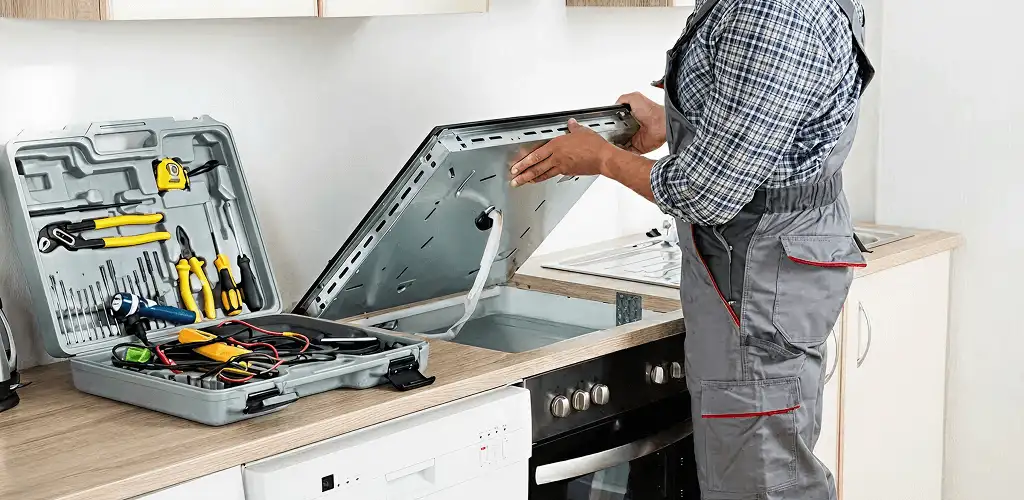 Handyman repairing a cooktop and checking wiring connections in Newark, NJ