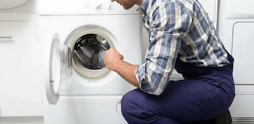 Handyman inspecting a dryer drum and internal parts for repair in Newark, NJ