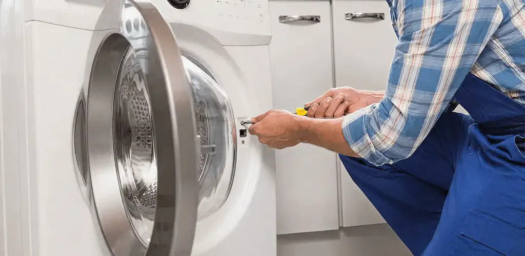 Handyman repairing a clothes dryer and checking electrical connections in Newark, NJ