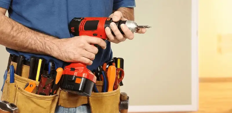 Handyman holding a power drill for home repairs and installations in Newark, NJ