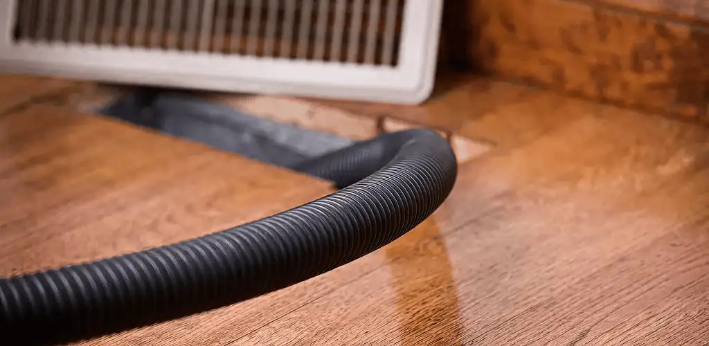 Air duct cleaning hose inserted into a floor vent for ductwork cleaning in Newark, NJ